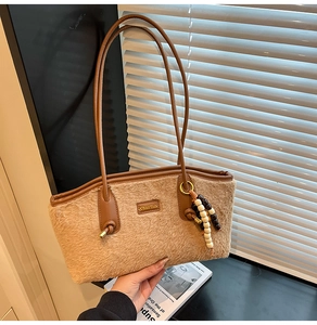 Detail der khakifarbenen Plüschtasche mit Lederbesatz und dekorativer Holzperlen-Quaste