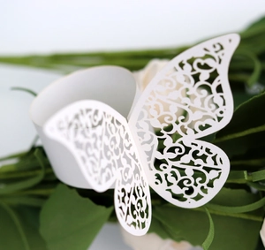 Macro shot of white laser-cut butterfly napkin ring with intricate vine patterns