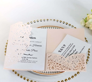 Macro view of pink laser-cut rose hollow invitation with elegant RSVP card set