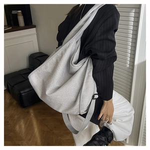 Detail of grey slouchy tote bag with wide adjustable strap and matte fabric texture