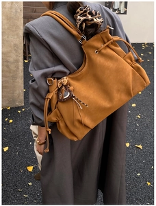 Detail of caramel tote bag with side drawstring and heart leopard print charm