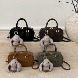 Detailed group shot of mini Boston bags in four colors with furry rabbit charms