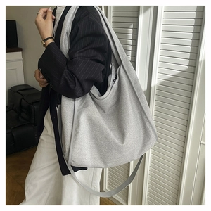 Detail of grey tweed tote bag texture and long shoulder strap for women's crossbody wear