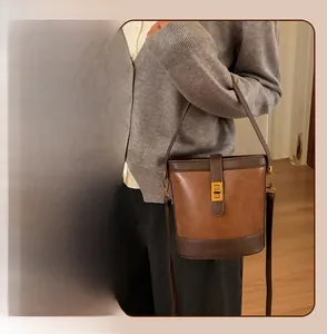 Detail of vintage brown bucket bag with a gold buckle and adjustable shoulder straps