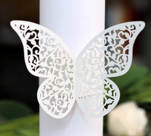 Detail of laser-cut butterfly napkin ring in white pearl paper for wedding decor