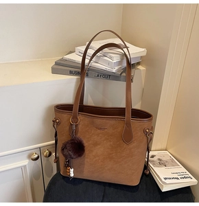 Détail du sac cabas marron en daim avec cordon de serrage et charm boule en peluche