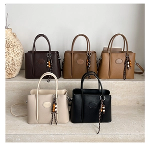 Detail view of five bucket bags in lychee textured leather with beaded charms and top handles