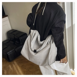 Detailed shot of large silver glitter tote bag with gray piping on a model