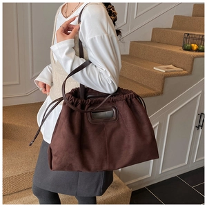 Détail du grand sac cabas en suède marron foncé avec poignée découpée et cordon de serrage