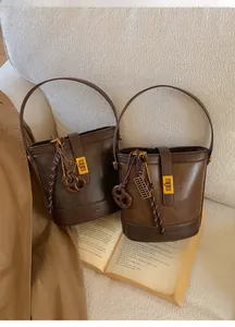 Close-up of retro matte bucket bags with golden metal buckles on an open book