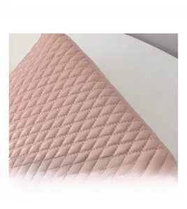 Macro shot of pink quilted faux leather texture with detailed diamond stitching pattern
