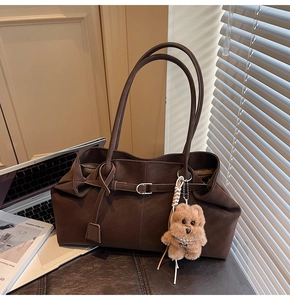 Deep coffee large tote bag with laptop and plush bear charm in a workspace setting