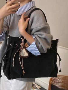 Minimalist black tote bag with side pockets and leopard heart charm for commuting