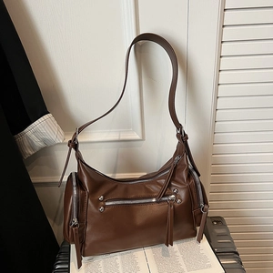 Macro detail of vintage brown shoulder bag with silver zippers and leather tassels