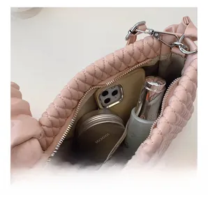 Detail showing internal capacity of the pink quilted shoulder bag for phone and makeup