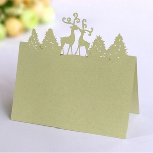 Elegant laser-cut light green place card featuring reindeer and forest design for Christmas