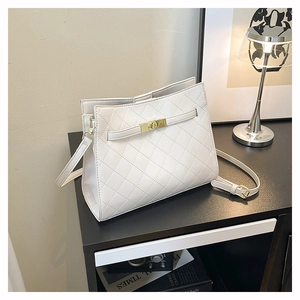 Detailed close-up of white quilted leather bag featuring a gold metal twist lock