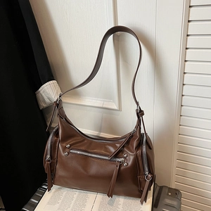 Detailed close-up of dark brown vintage faux leather shoulder bag with silver zippers