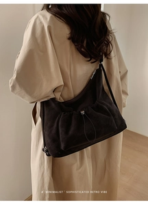 Detail of vintage brown suede tote bag with drawstring pocket and slim shoulder straps