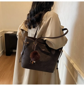 Détail du grand sac cabas vintage marron foncé avec charme pompon et lettrage logo