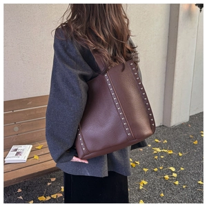 Brown lychee leather tote bag featuring vertical metal rivet details and autumn vibe