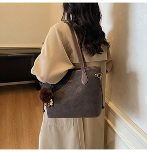 Détail du grand sac cabas en daim avec pompon en fourrure et pendentif en perles