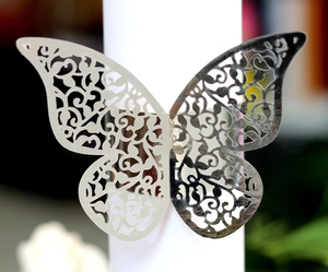 Detailed view of silver butterfly napkin ring with laser-cut vine patterns for weddings