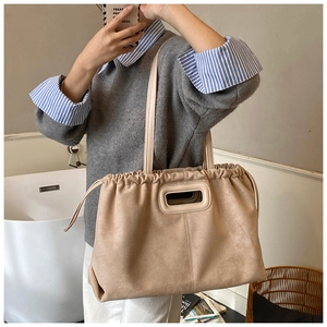Détail du sac cabas en daim minimaliste avec cordon de serrage et poignée rectangulaire