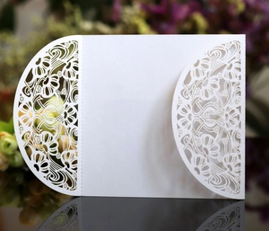 Detail of white laser-cut floral invitation cover with intricate hollow pattern