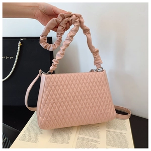 Detail of pink quilted shoulder bag with pleated handle and silver metal rings