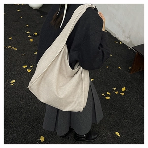 Close-up of minimalist oatmeal canvas tote bag with wide strap on autumn ginkgo leaves