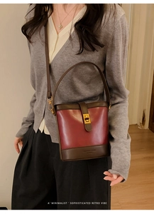 Close-up of vintage burgundy bucket bag with golden twist lock and logo detail