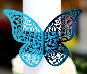 Macro view of blue laser-cut butterfly napkin ring with intricate vine textures