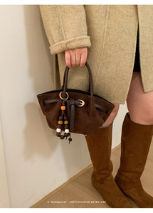 Detailed view of dark brown suede tote bag with leather straps and decorative beads