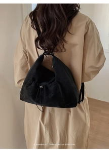 Minimalist black faux suede drawstring backpack showing a sophisticated retro vibe on model