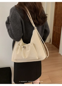 Detail of minimalist cream suede-style shoulder bag with decorative drawstring pocket