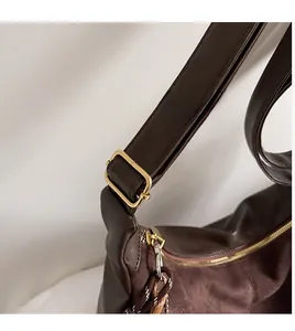 Gros plan détaillé du sac seau marron foncé avec bandoulière réglable et fermoir doré