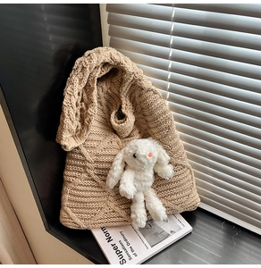 Detail of light khaki knit tote bag with diamond pattern and plush bunny charm