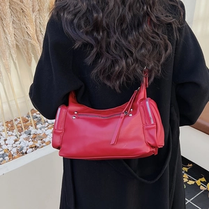 Detail of red leather hobo bag with silver studs and multiple zipper pockets