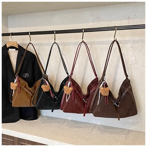 Detail view of retro tote bags in four colors with cute teddy bear pendants on a display