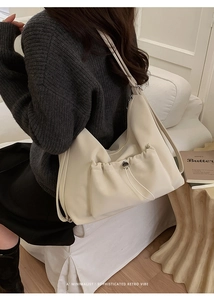 Detail of minimalist beige large crossbody bag with adjustable drawstring pocket