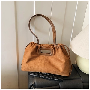 Détail du sac cabas en daim caramel avec plis à cordon et poignée découpée élégante