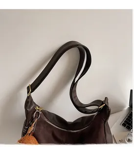 Détails des coutures en cuir et daim marron sur le sac cabas avec quincaillerie dorée