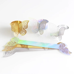 Close-up of laser-cut butterfly napkin rings in gold, silver, and iridescent finishes