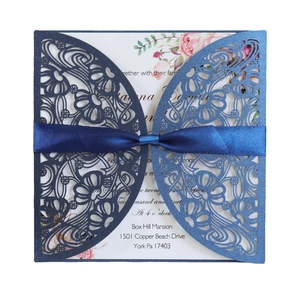 European laser-cut wedding invitation in navy blue with elegant silk ribbon bow