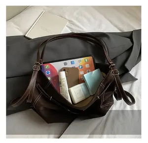 Spacious interior of a dark brown tote bag showing capacity for tablets and cosmetics