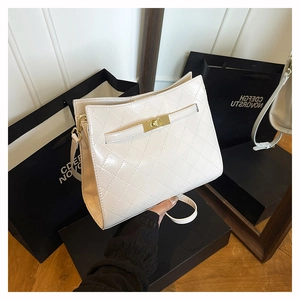 Detail of creamy white quilted shoulder bag with glossy finish and gold square buckle closure
