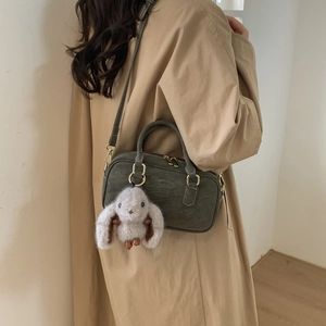 Detail of dark grey retro pillow bag in brushed leather with rabbit plush charm