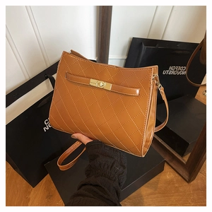 Close-up of brown quilted leather handbag with gold metal clasp and premium texture
