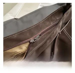 Macro view of vintage brown suede tote showing silver zipper and stitching details